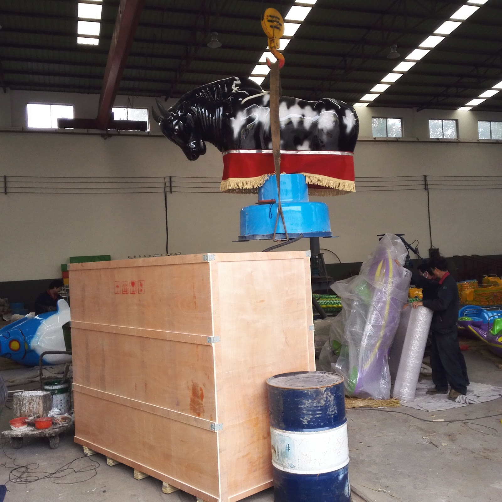 Mechanical bull being lifted onto its export crate by hoist